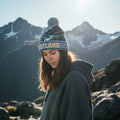 Person wearing a beanie and hoodie with mountains in the background