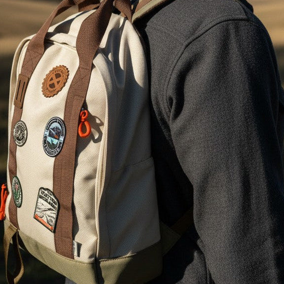 Man with a backpack and cap standing in a scenic outdoor setting