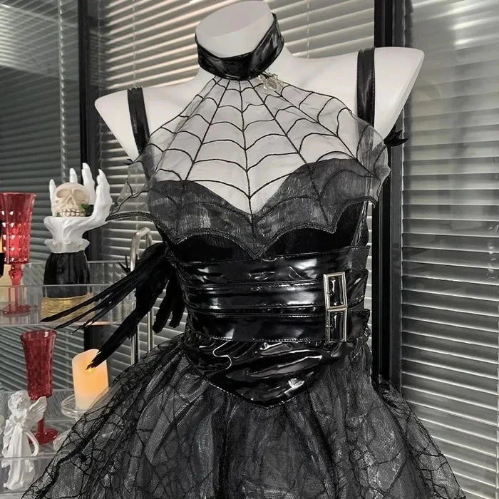 Black and white spider-web patterned dress on a mannequin against a blurred indoor background.